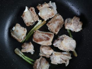 7、排骨板栗香焖饭,不粘锅热油，加入洗干净后的葱白，小火煸炒出香味后，加入排骨，小火将排骨煎香。
