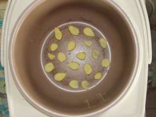 6、五花肉胡萝卜土豆焖饭,如图将姜片均匀铺在电饭煲底