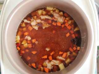 13、五花肉胡萝卜土豆焖饭,将淘好的米放入电饭煲中,按正常的煮饭键,自动跳后不揭锅多焖10分钟左右即可出锅