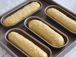 9、胡萝卜热狗面包，做营养美味早餐,放入发酵箱或者是环境35度左右的环境中，发酵大约1.5倍大。取出后刷一层薄薄的蛋液，并撒上白芝麻。