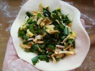 5、韭菜鸡蛋馅儿包子,取一块面团，擀圆，包入馅儿料。面团不要擀的太薄，要想面团宣软，外皮可以稍微厚一些。