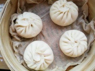 6、韭菜鸡蛋馅儿包子,包好的包子，放在蒸屉上继续醒发15分钟。包好的包子还在发酵，所以包子与包子之间保持一定的距离。