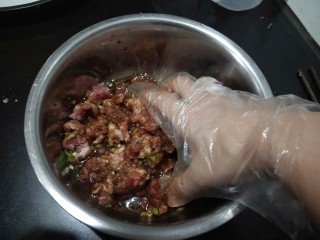 6、肉沫粉丝包,可以用筷子顺时针搅拌。我习惯用手抓匀,顺便可以抓开粘连得肉块。