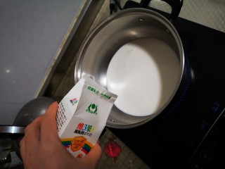 2、自制奶茶,把奶倒入锅中煮。