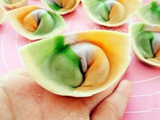 15、彩虹馄饨（宝宝超爱吃）,把下面两个角往里带捏在一起，馄饨就包好了。