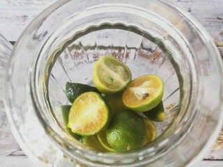 2、冰糖青桔,小青柠切半，先放入一层小青柠