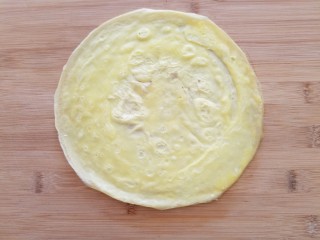 2、菠萝蛋包饭,平底锅小火加热，锅里抹薄油倒入蛋液，转去动锅使蛋液均匀铺满锅底煎成圆形蛋饼，表面凝固后盛出，不用翻面。