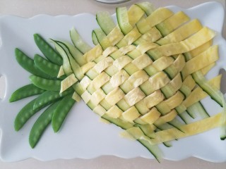 11、菠萝蛋包饭,把编好的蛋饼盖在炒饭上面，挪动蛋饼时动作轻柔，别把蛋饼弄散了，我是用两把菜刀左右插入蛋饼下托起再盖在炒饭上的。