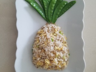 10、菠萝蛋包饭,炒好的米饭盛到盘子里，用勺子整形成菠萝的形状，上窄下宽。