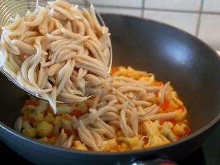 6、西红柿牛肉炒剪刀面,12.然后将“过程7”的剪刀面捞出，倒入炒锅中。