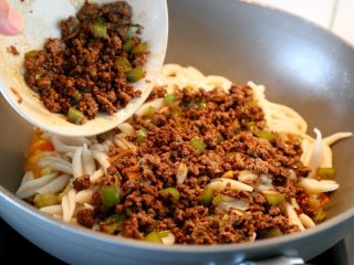 7、西红柿牛肉炒剪刀面,13.再将“过程9”炒好的牛肉末倒入剪刀面上面。