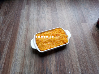 9、椰蓉南瓜糕,将奶锅里的食材倒入容器，将表面抹平；