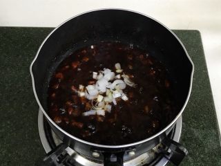 6、炸酱面,直到酱汁的水分被煮干，放入切好的大葱。