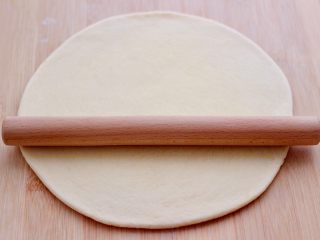 5、奶香小花朵馒头,用擀面杖擀成半厘米厚的薄面皮。