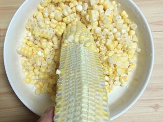 2、香甜南瓜玉米汁,将玉米粒从玉米上切下来。