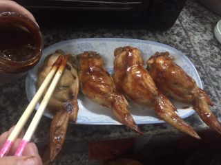 20、鸡翅包饭,第一次烤好鸡翅包饭后，把鸡翅包饭取出，涂上烧烤酱，两面都要均匀的涂上。
