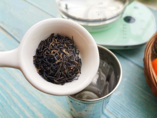 2、自制高颜值低卡水果茶,茶壶中倒入热水,将红茶放入养生壶中。
