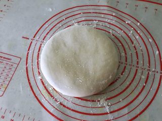 5、姜黄花卷,饮料做,面团拿出来在案板上揉几下后,用擀面擀成3毫米薄椭圆形。
