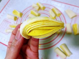 11、姜黄花卷,饮料做,拿一半起来,两手各捏一头,扭一下,左手朝内扭右手朝外扭,将两头收到底部捏好,纹路漂亮的花卷就成型了。