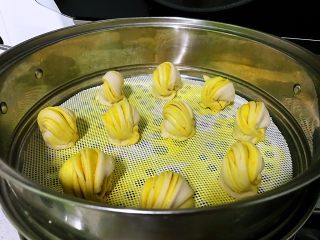 13、姜黄花卷,饮料做,蒸锅中水烧到微热40度左右,关火,将装有花卷的蒸笼放入,盖上盖子醒发约30分钟,看到花卷有明显的变大,大约为原来的1.5倍时,开火,水开后蒸15分钟,关火焖约2分钟。