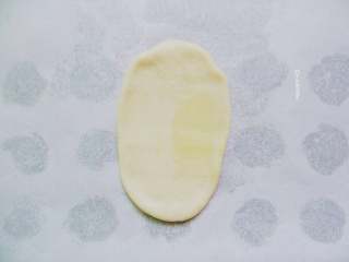 6、糖火烧,取第一只包好的饼皮，按扁，擀成牛舌状