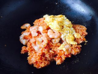 14、#炒饭秀# 番茄虾仁炒饭,放入炒好的虾仁和炒好的鸡蛋，翻炒均匀即可。