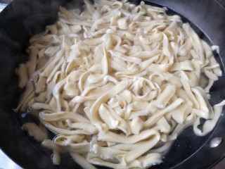 9、时蔬炒刀削面,大火煮开，用漏勺沿锅边将面顺时针推起。