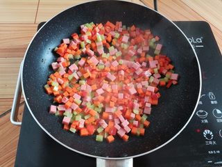 11、菠萝蛋炒饭,锅里放入少量油翻炒一下蔬菜丁和火腿肠丁