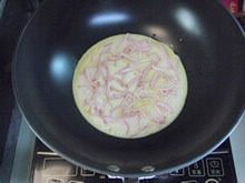 6、披萨蛋饼,大概40秒以后，把火关掉，在蛋糊面上轻轻铺上培根丝。