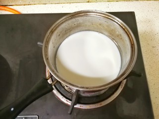 7、浓香黑米椰奶饮,把牛奶倒入小锅里,开小火至牛奶微微发热,边缘起小泡泡即可,注意不要煮沸了,