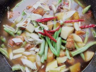 7、五花肉豆角焖面,加适量开水至与菜平齐的程度。放入干辣椒、八角、葱姜蒜、盐、一小勺老抽熬煮