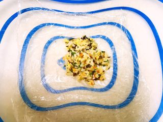 19、甜虾饭团,取一片保鲜膜，在保鲜膜上放入一勺炒饭