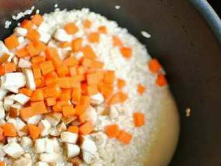 4、排骨焖饭,东北大米和圆糯米放在一起淘洗干净后，放入香菇丁儿和胡萝卜丁儿。