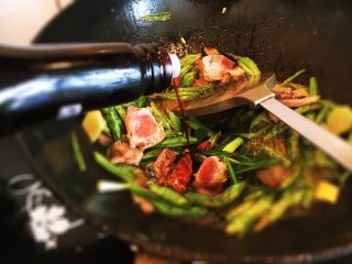 8、豆角焖面,加生抽和老抽调味翻炒均匀。