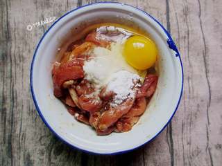 5、炸酥肉,加入一个鸡蛋，.将面粉与淀粉加入肉条中，继续搅拌至完全均匀