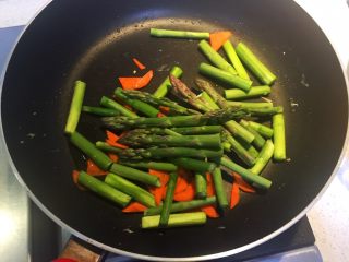 9、芦笋木耳炒鸡蛋,热锅下油，倒入芦笋和胡萝卜翻炒均匀。