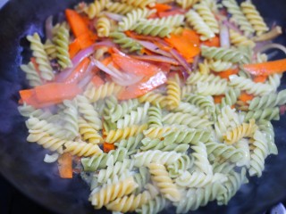 7、墨鱼杂蔬炒螺丝意面,加入意面。