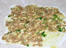 6、千层肉酥饼,再用一半的肉馅抹在面皮上，除了右下角那块不抹