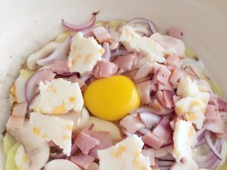 8、培根蘑菇薯片薄饼,在中间打上鸡蛋，并铺上芝士碎