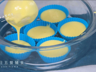 7、蛋黄米糕,将面糊一个个舀入刷过油的模具中。