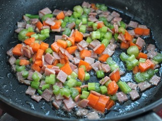 8、火腿蛋炒饭,再放入芹菜和胡萝卜翻炒两分钟