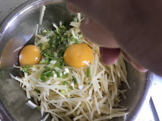 4、黄金土豆丝饼,加入葱花，打入两个鸡蛋
