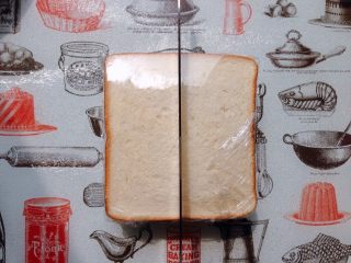 20、日式鸡胸肉蛋三明治,盖上另一片吐司，用保鲜膜包好，将三明治旋转90度，用锯齿刀对切开