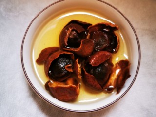 3、土鸡蛋桂圆枸杞红枣茶,手轻轻撕破外壳，桂圆壳还留在锅里，继续炖煮。