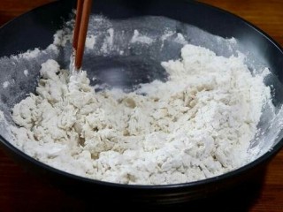 5、香甜红糖锅盔,将酵母水倒入面粉中,边倒边用筷子搅拌。
