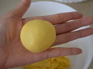 12、玉米发面饼,现在的状态略微粘手，用两个手掌心轻轻搓圆。如果感觉粘手严重，可以在手上少抹点干面粉继续搓。