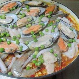 15、西班牙海鲜饭,将青豆洒在表面,盖上锅盖转中大火煮8分钟即可。出锅前放入适量欧芹碎