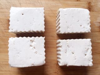 2、吃豆腐～肉末蒸豆腐,用狼牙刀把豆腐切成大小差不多的四份。