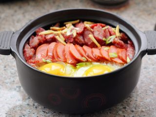 12、腊肠煲仔饭,放姜丝，码上香肠并打两个鸡蛋进去。
