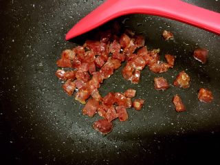 6、腊肠粒黄金炒饭,煎至变透明且出油，沥油捞起